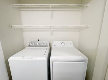 An empty laundry room with two washes and a dryer